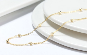 Nahaufnahme einer minimalistischen 925er Sterling Silber Kugelkette auf weißem Porzellan