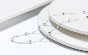 Detailansicht der S925 Sterlingsilberkette mit 3mm polierten Perlen auf weißem Porzellan