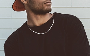 Detailed view of a 3mm silver herringbone snake chain worn by a male model