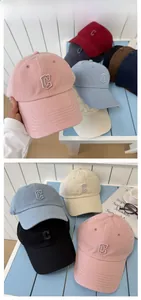 Détail du logo 'C' brodé sur des casquettes de baseball en coton de diverses couleurs