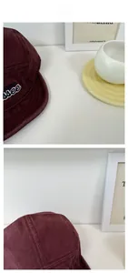 Detailed close-up of retro burgundy corduroy five-panel cap with letter embroidery