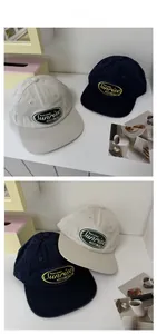 Detail view of cotton twill baseball caps with vintage embroidered sunrise flower badges