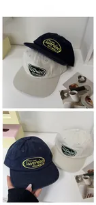 Detail of navy and beige cotton baseball caps with vintage embroidered logo patches