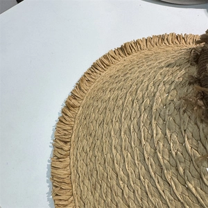 Detailed macro shot of weave texture and frayed fringe edges on a straw sun hat