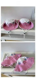 Detail showing pink gradient cowboy hat with star patches and distressed frayed edges