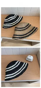 Detail of striped knitted sun hats in black, white and khaki with tile texture display