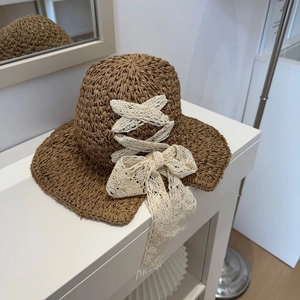 Foldable brown straw sun hat with white lace ribbon and bow detail for beach vacations