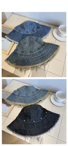 Flat lay detail of distressed denim bucket hats with frayed edges and metal star rivets
