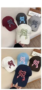 Detail display of cotton baseball caps with unique snake-bow embroidery in multiple colors