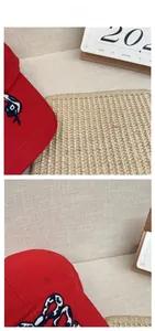 Macro detail of red cotton baseball cap featuring blue snake embroidery and stitching