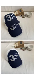 Detail of navy blue and white baseball cap with silver embroidered number three motif
