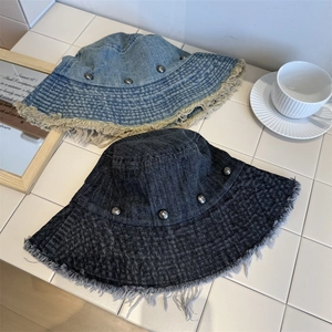 Distressed denim bucket hat with fringe edges and metal rivet details for women