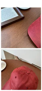 Detail der roten Vintage PU-Leder Baseballkappe mit matter Textur auf dunklem Holztisch