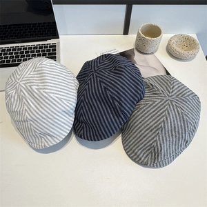 Vintage striped flat cap beret for women shown in multiple colors on a minimalist desk