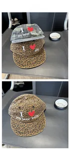 Detail of camouflage and leopard print baseball caps with embroidered I love my beer belly slogan