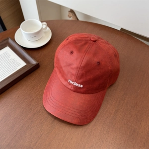 Rote Vintage PU-Leder Baseballkappe mit rocless Stickerei auf Holztisch