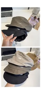 Detailed view of striped textured beret caps with metal CM tag and adjustable drawstring