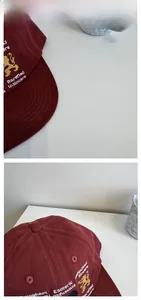 Détails de broderie de lion et texte blanc sur casquette en coton rouge foncé