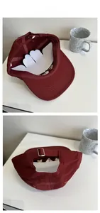 Détail d'une casquette en toile bordeaux avec broderie snoopy et boucle métallique réglable