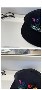 Detailed tile display of black baseball cap featuring colorful floral garden embroidery