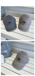 Detailed embroidery on vintage plaid baseball caps in dark grey and khaki cotton canvas