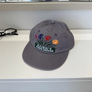 Grey washed cotton baseball cap with floral embroidery and green label patch