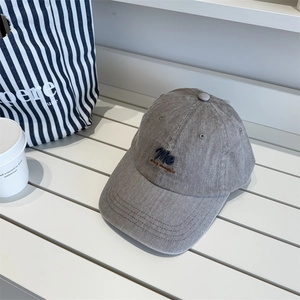 Retro grey corduroy baseball cap with vintage embroidery on a white bench