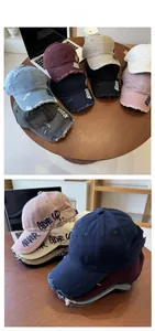 Detail display of distressed denim baseball caps with Never Give Up embroidery in many colors
