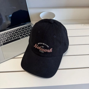Classic black cotton baseball cap with pink embroidery on a casual desktop setting