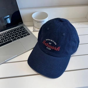 Deep blue corduroy baseball cap with vintage embroidery on a desk setting
