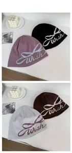 Vue détaillée des bonnets en tricot noir, bordeaux, café et gris clair avec nœuds