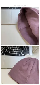 Detail view of purple knitted beanie showing fine stitch texture and elastic interior seams