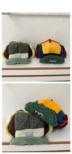 Detail of warm winter trapper hat with cartoon eyes embroidery and plush earflaps