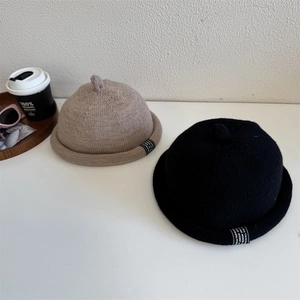 Gebreide docker muts in zwart en beige met opgerolde randen en stijlvol label