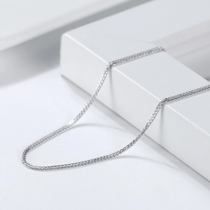 Polished S925 sterling silver wheat chain necklace on minimalist geometric jewelry display