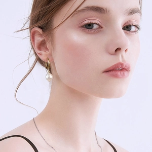 Elegant 925 sterling silver hoop earrings with natural baroque pearls on female model