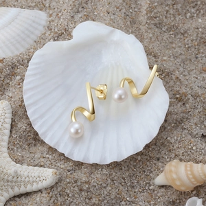925 silver gold spiral earrings with baroque pearls displayed on a seashell and sand