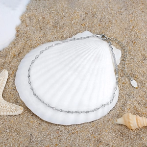 Minimalist S925 sterling silver butterfly chain anklet displayed on white seashell and sand