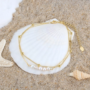 Close-up of S925 sterling silver double-layer pearl anklet on a white seashell