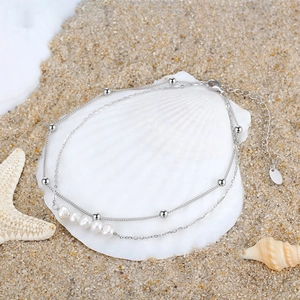 Double-layered 925 silver pearl anklet on white seashell with starfish on sand