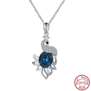 Macro detail of a 925 sterling silver peacock pendant with a faceted blue crystal stone