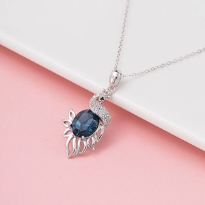 Elegant peacock pendant necklace with deep blue crystal and sparkling zircon accents