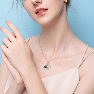 Elephant pendant necklace with blue crystal and silver chain worn on model