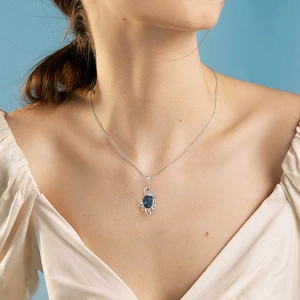 Exquisite silver peacock necklace featuring a deep blue crystal pendant on a delicate chain