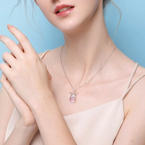Cute bunny necklace with pink crystal pendant on silver chain worn by a model