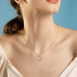 925 silver pearl necklace with gold wire wrapping and matching earrings on a model