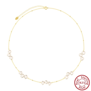 Dettaglio della collana con perle barocche, catena dorata e marchio in argento S925
