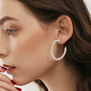 French style 14K gold plated C-shaped pearl hoop earrings worn by a model with dark hair