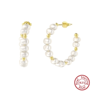 Detailed view of S925 sterling silver stamp on C-shaped gold pearl hoop earrings