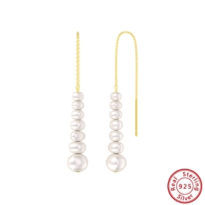 Close-up of 925 sterling silver gold-plated chain earrings with graduated white pearls